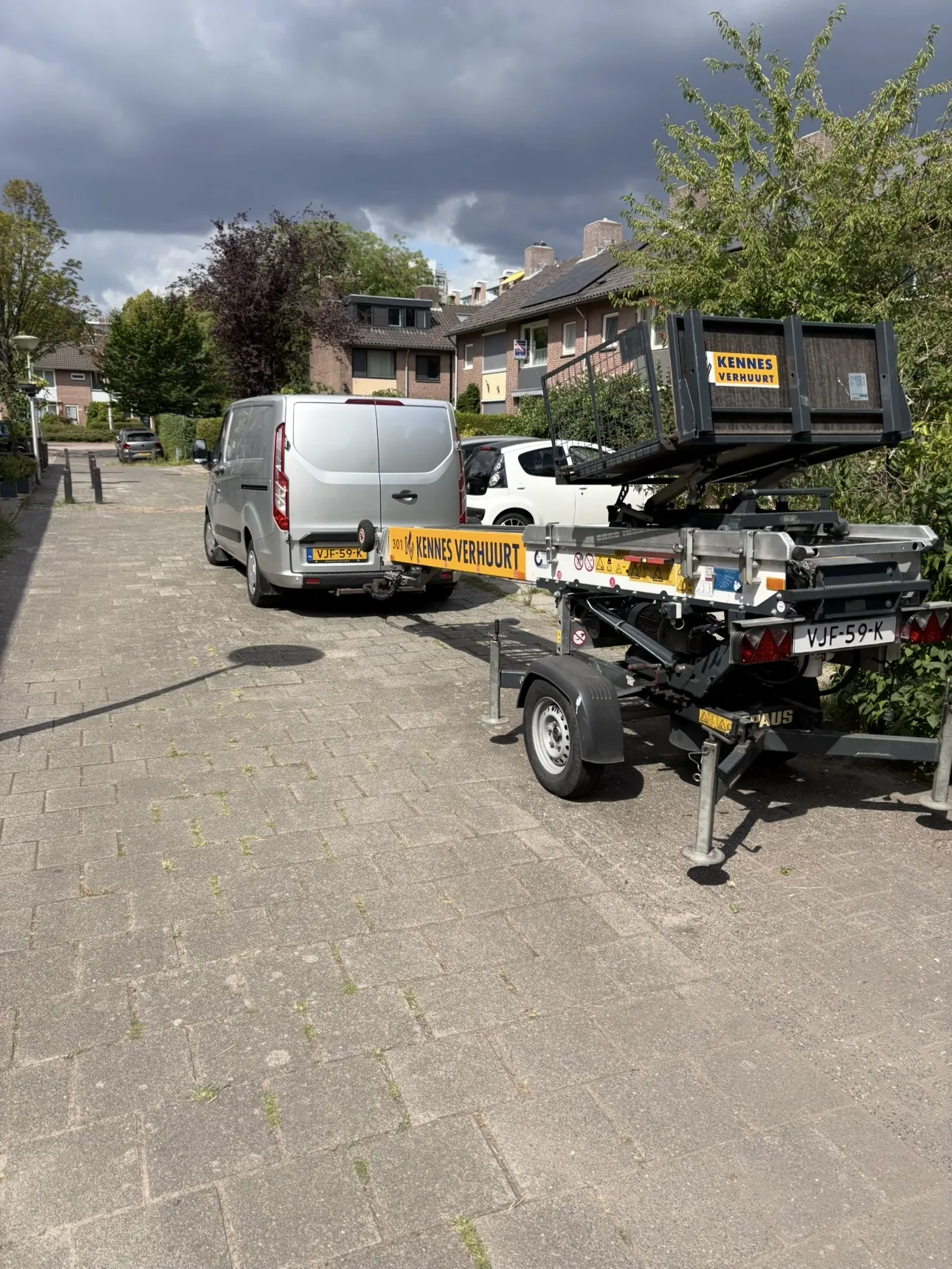 De bus met aanhanger van J.Dat Dakwerken voor de deur bij een klus