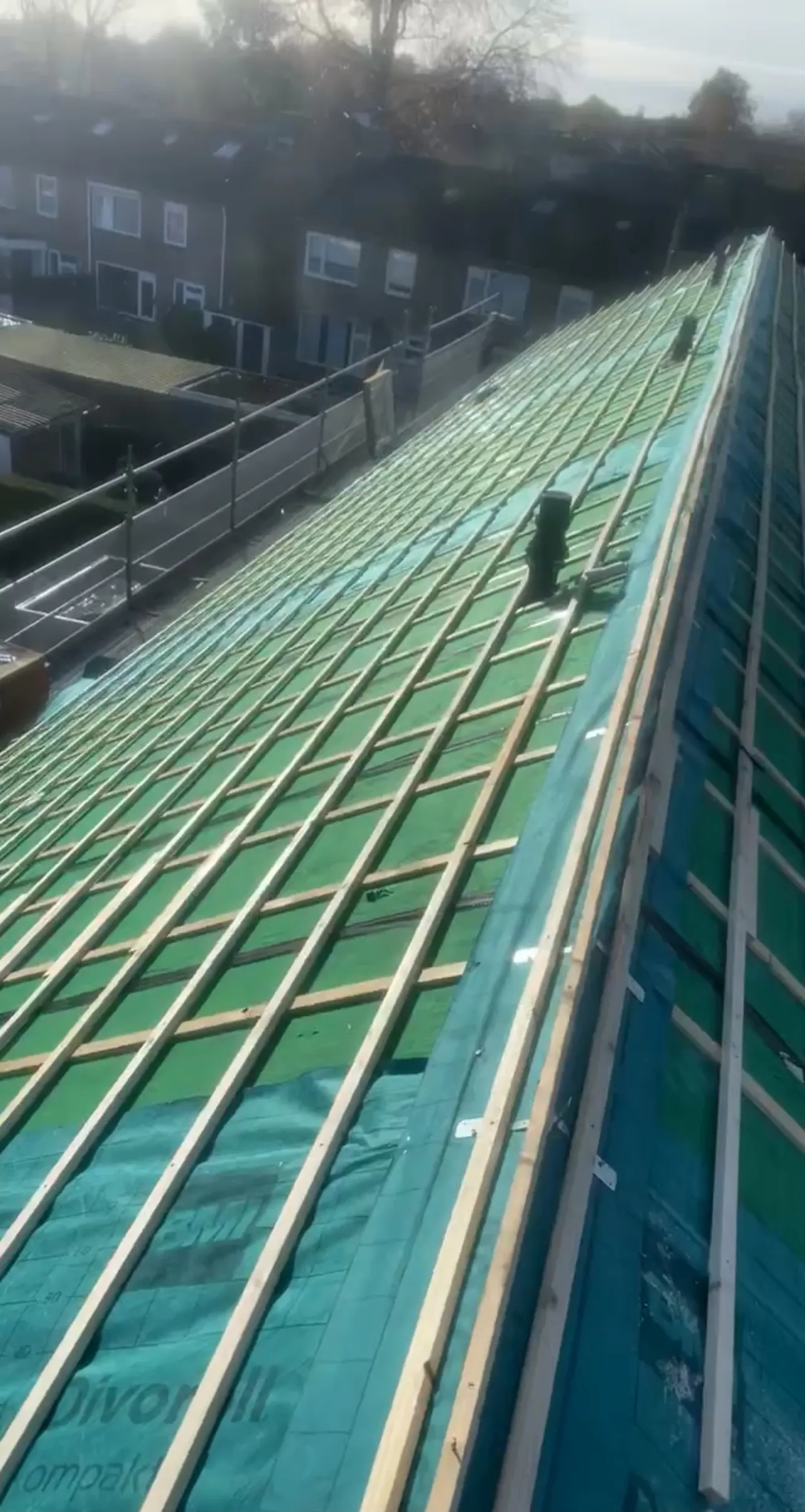 Dakvlak in renovatie met groene waterkerende folie en nieuwe panlatten