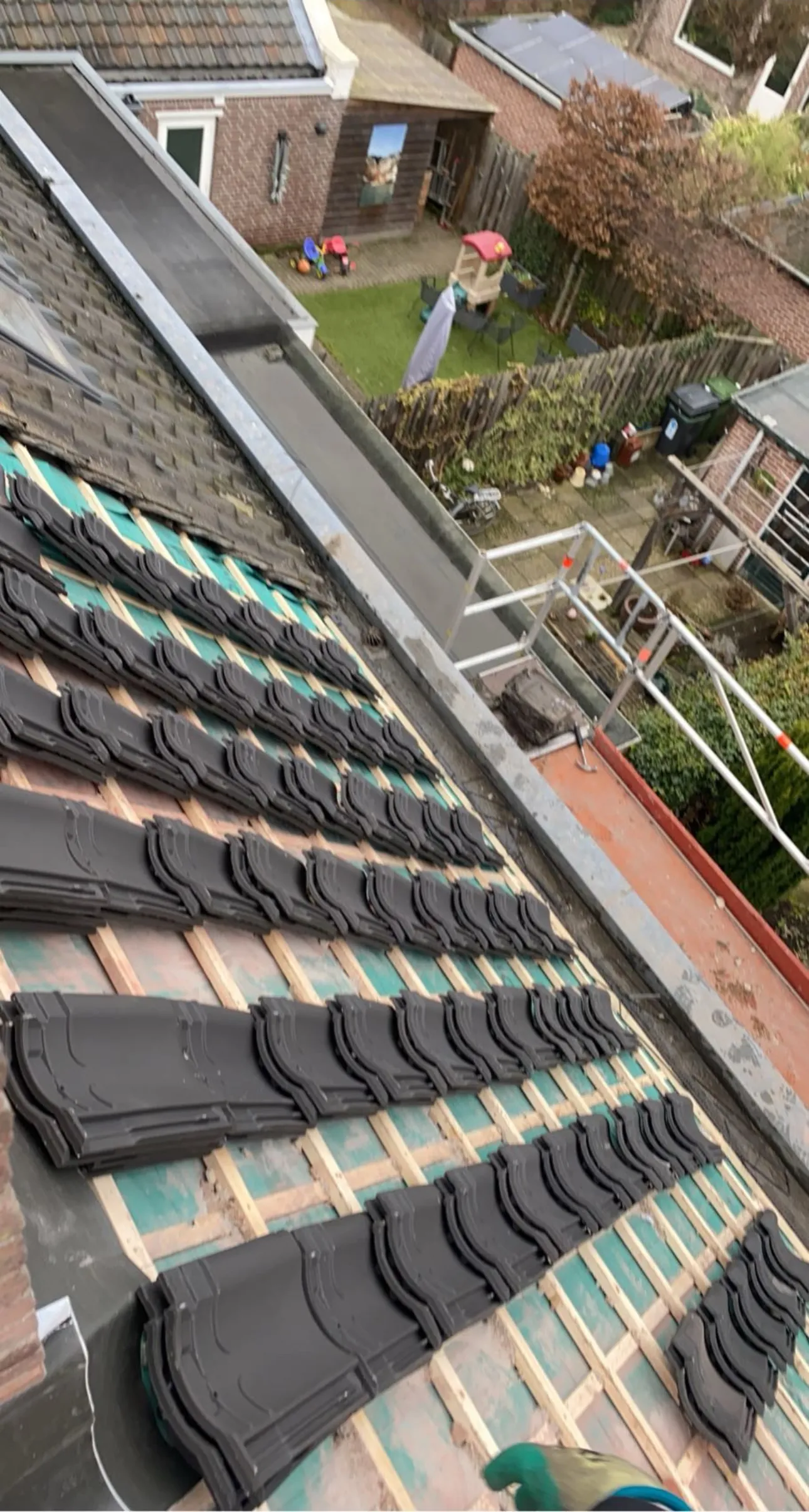 Dakpannen die rij voor rij op de panlatten worden gelegd