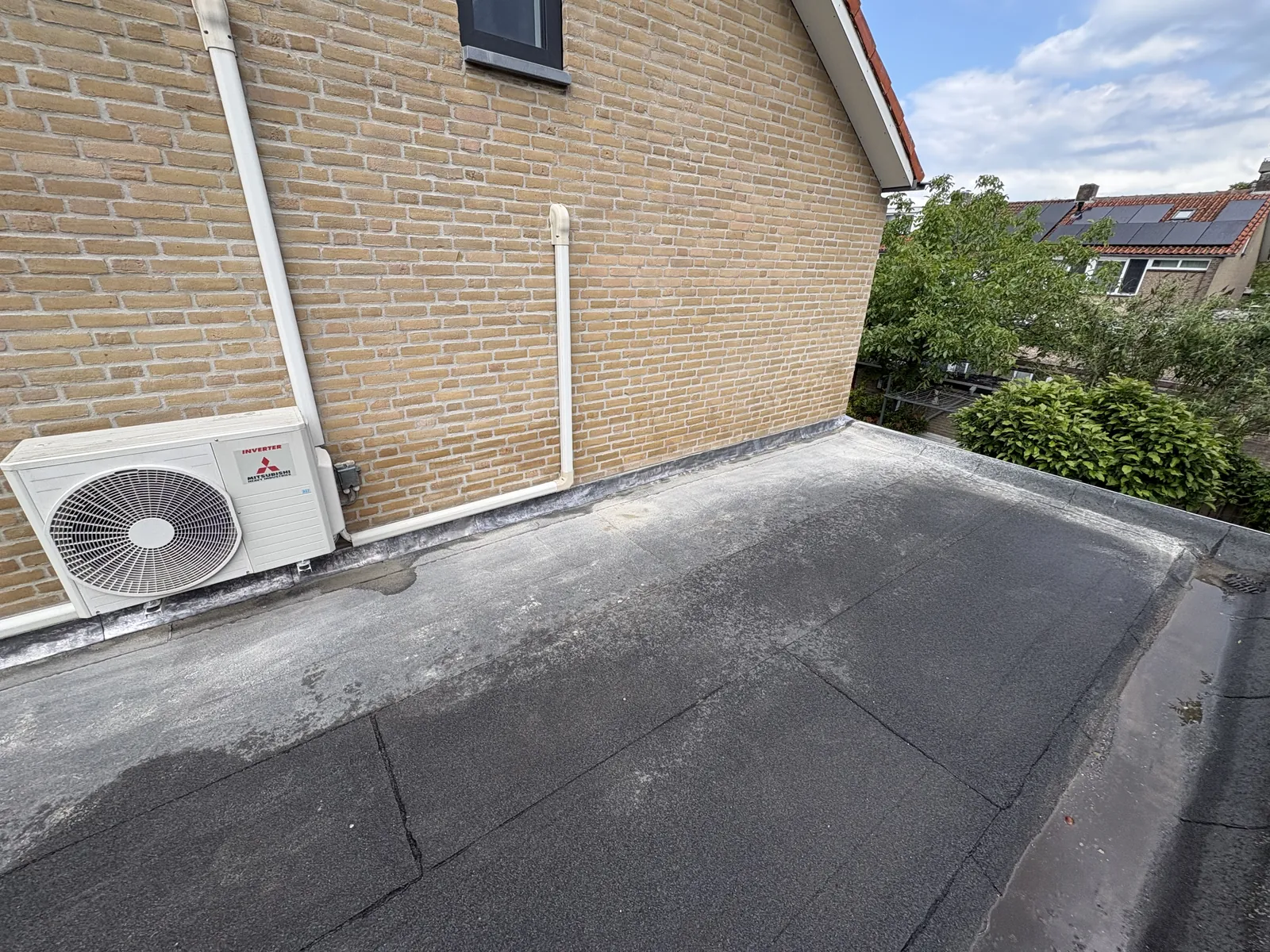 Airco-buitendeel op een plat dak met nette doorvoeren