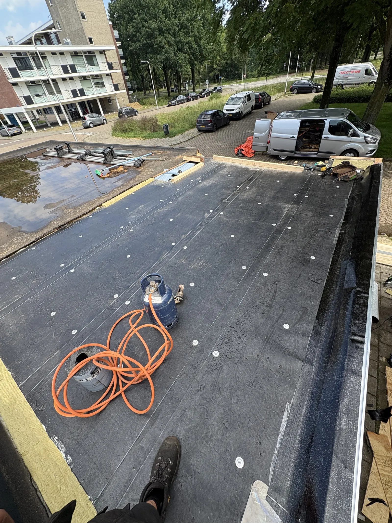 Plat dak waarop nieuwe bitumen dakbedekking wordt aangebracht