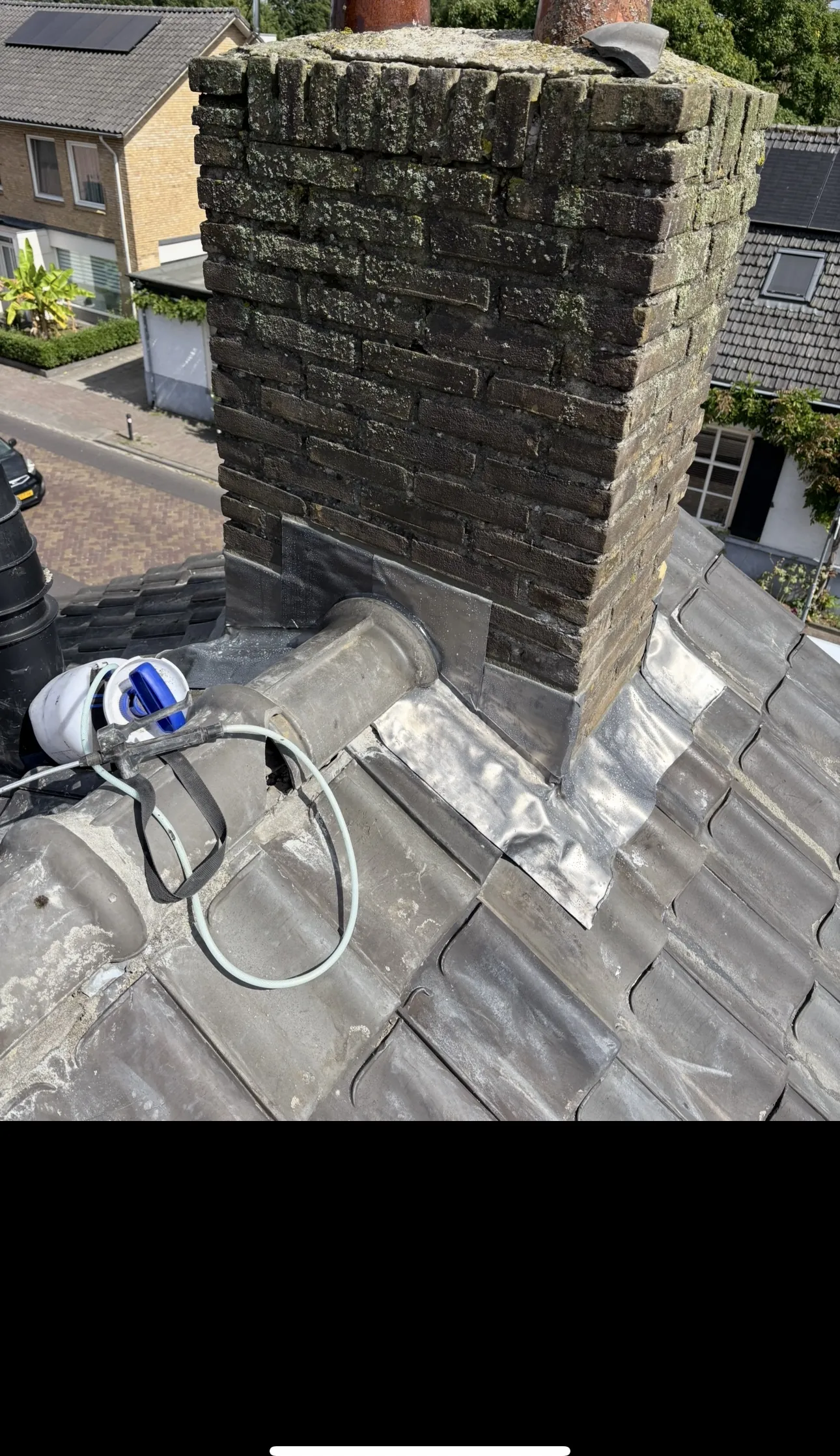 Gemetselde schoorsteen op een pannendak tijdens renovatie